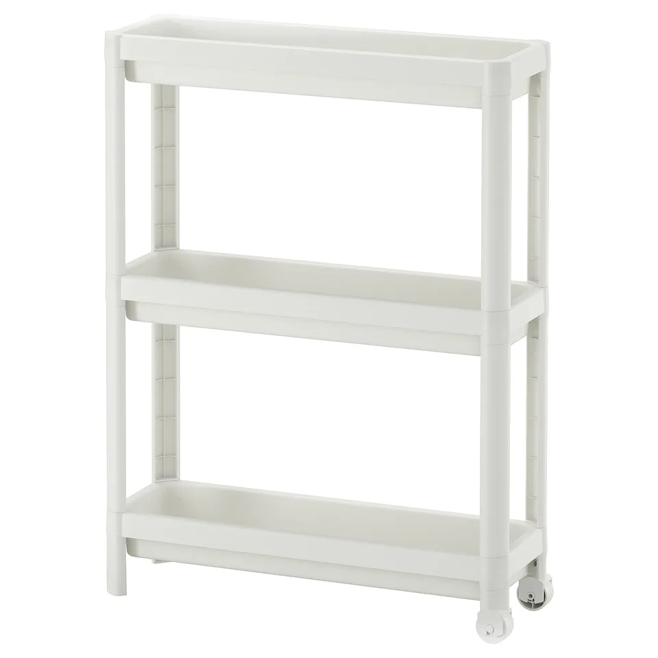 A white VESKEN storage trolley with three shelves, designed for narrow spaces, featuring a stable and mobile structure with wheels.