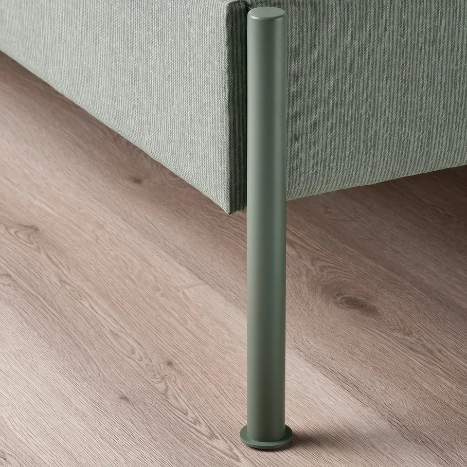Close-up of modern upholstered bed frame with sleek, green metal leg; soft, striped headboard.