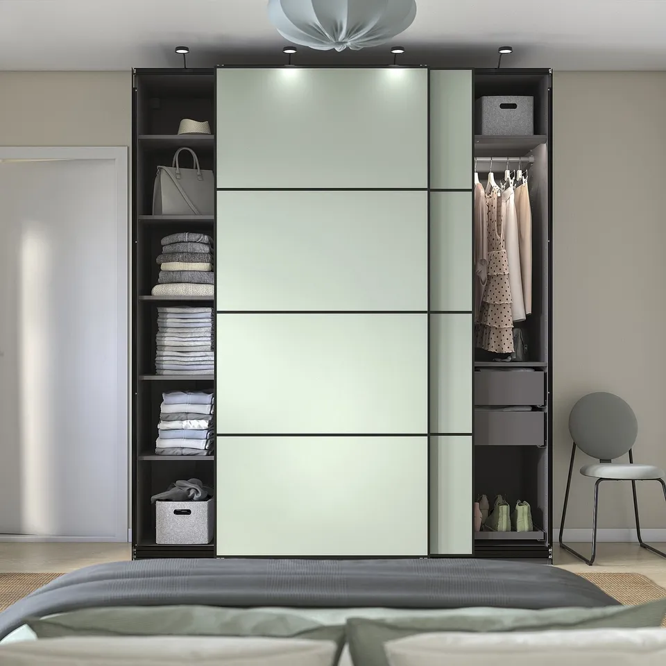 Modern wardrobe with sliding doors shows organised storage and integrated lighting.