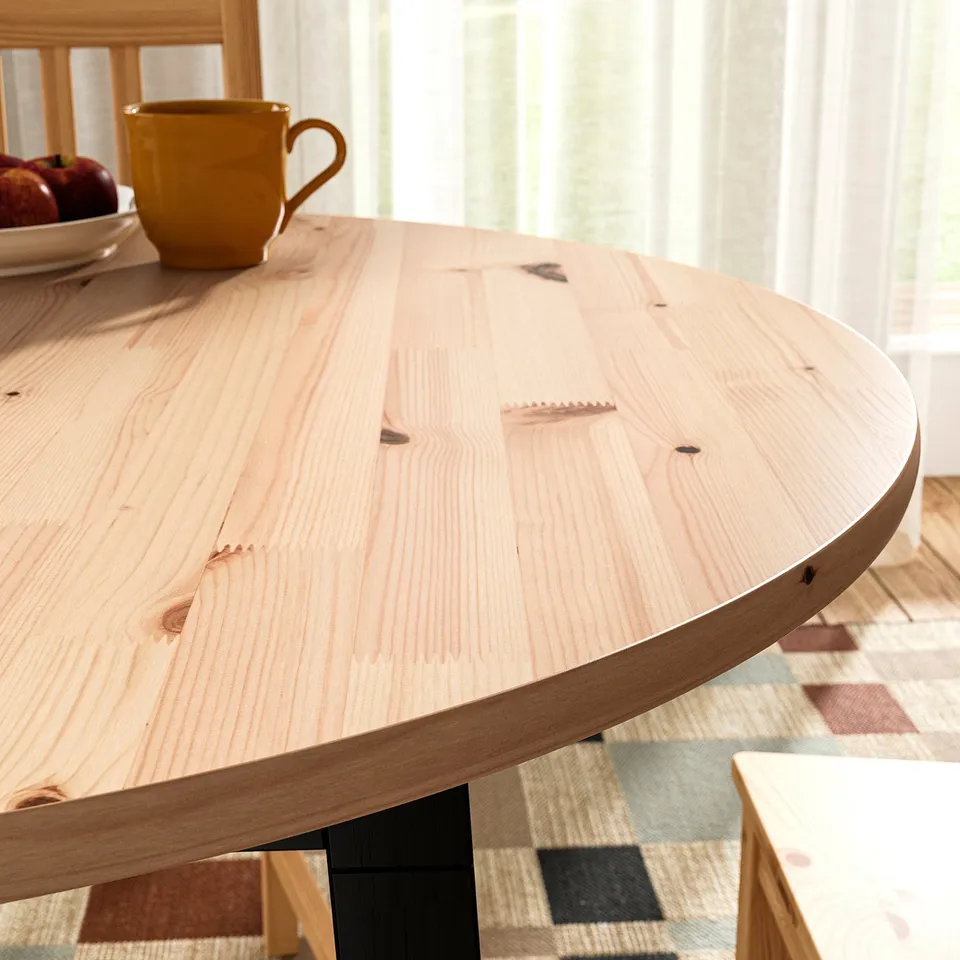 Wooden table with grain texture, apples, mug on balcony with chairs and curtains.