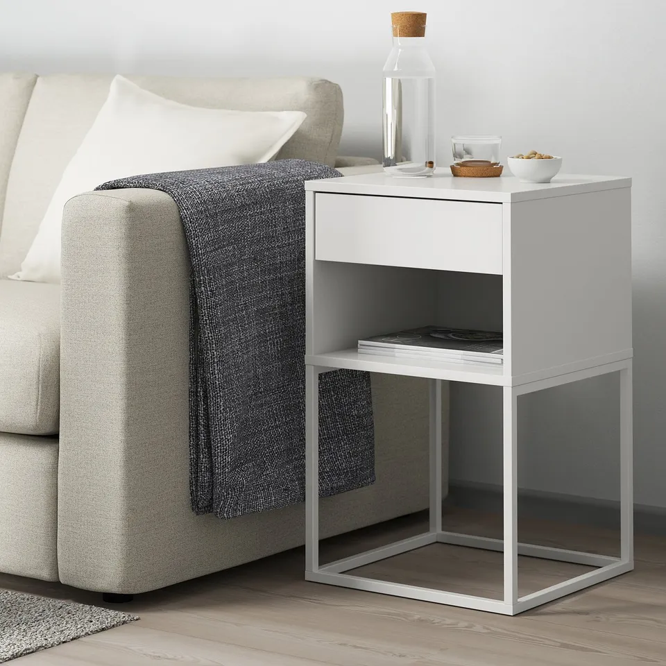 VIKHAMMER side table, small, next to grey sofa with drawer & shelf.