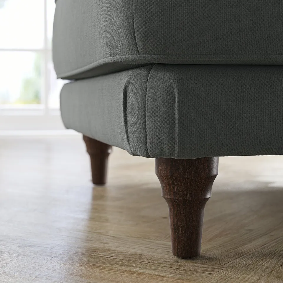 Close-up of grey ESSEBODA footstool on wood floor. Dark wood legs, cushioned seat.