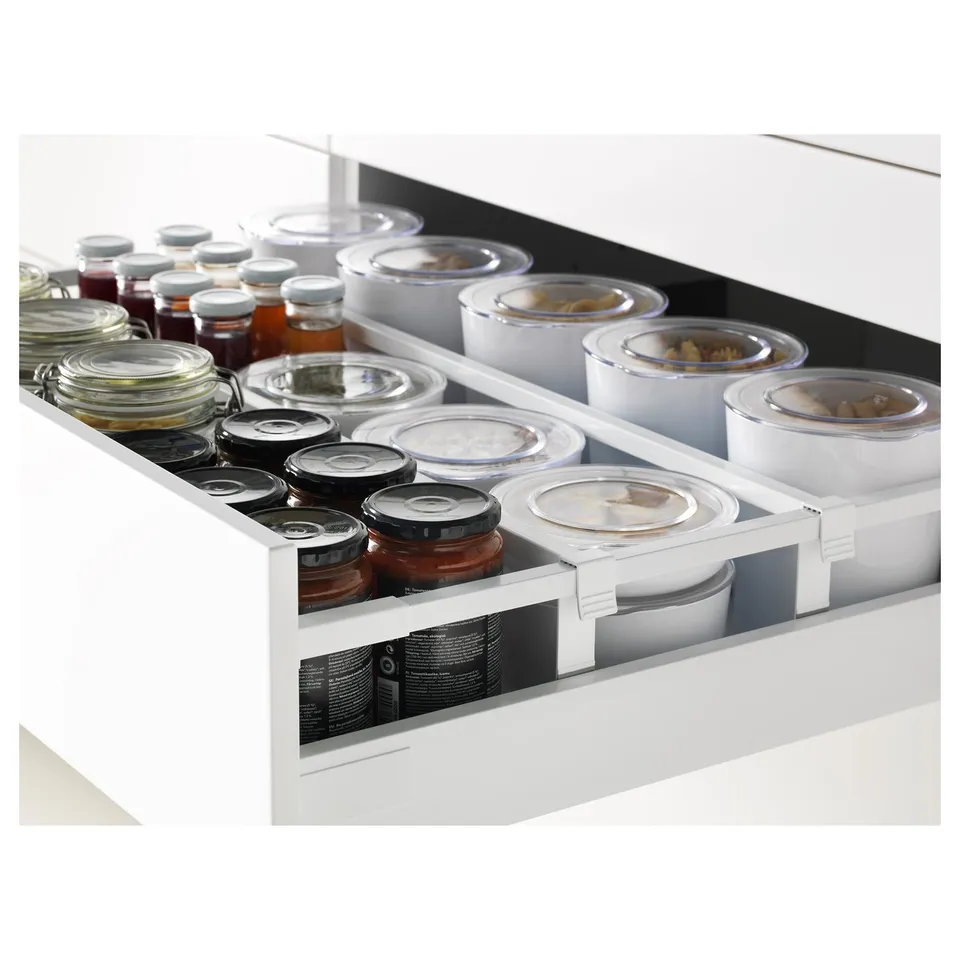 White kitchen drawer, filled with various size jars and containers, featuring self-closing drawers and included dampers for smooth closure.