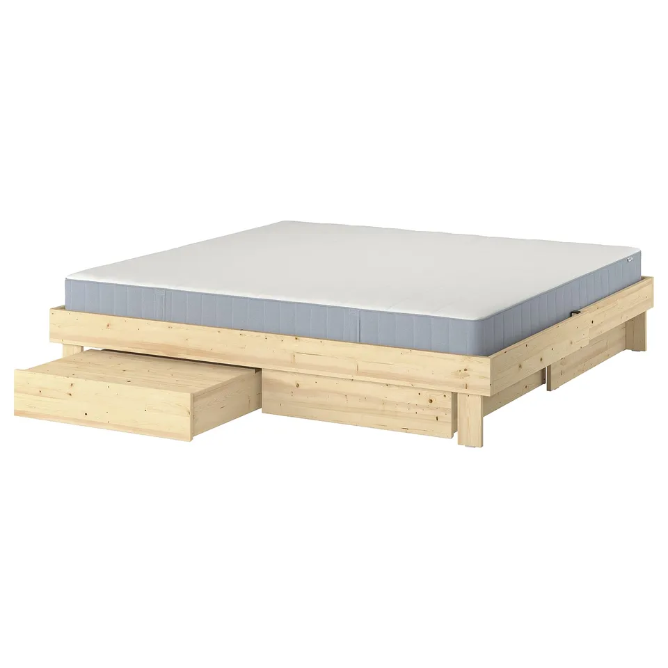 GLAMBERGET extendable bed in natural wood with white mattress, featuring storage boxes and tray tables for space efficiency.