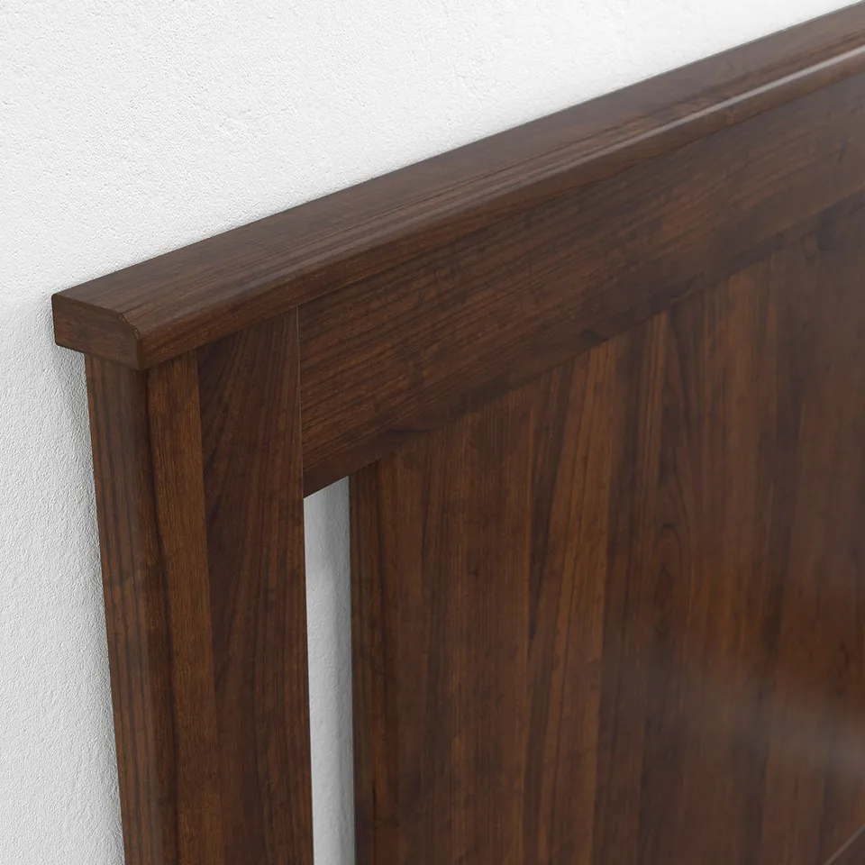 A close-up of a sturdy wooden bed frame with smooth edges and high legs, highlighting its quality craftsmanship.