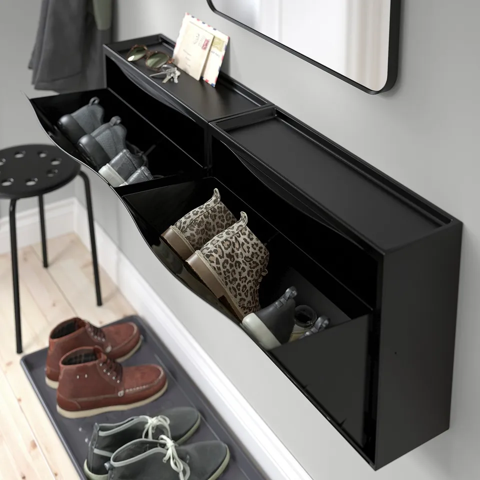 Black TRONES shoe cabinet, holding shoes in compartments, with a top surface for small items like keys and phones.