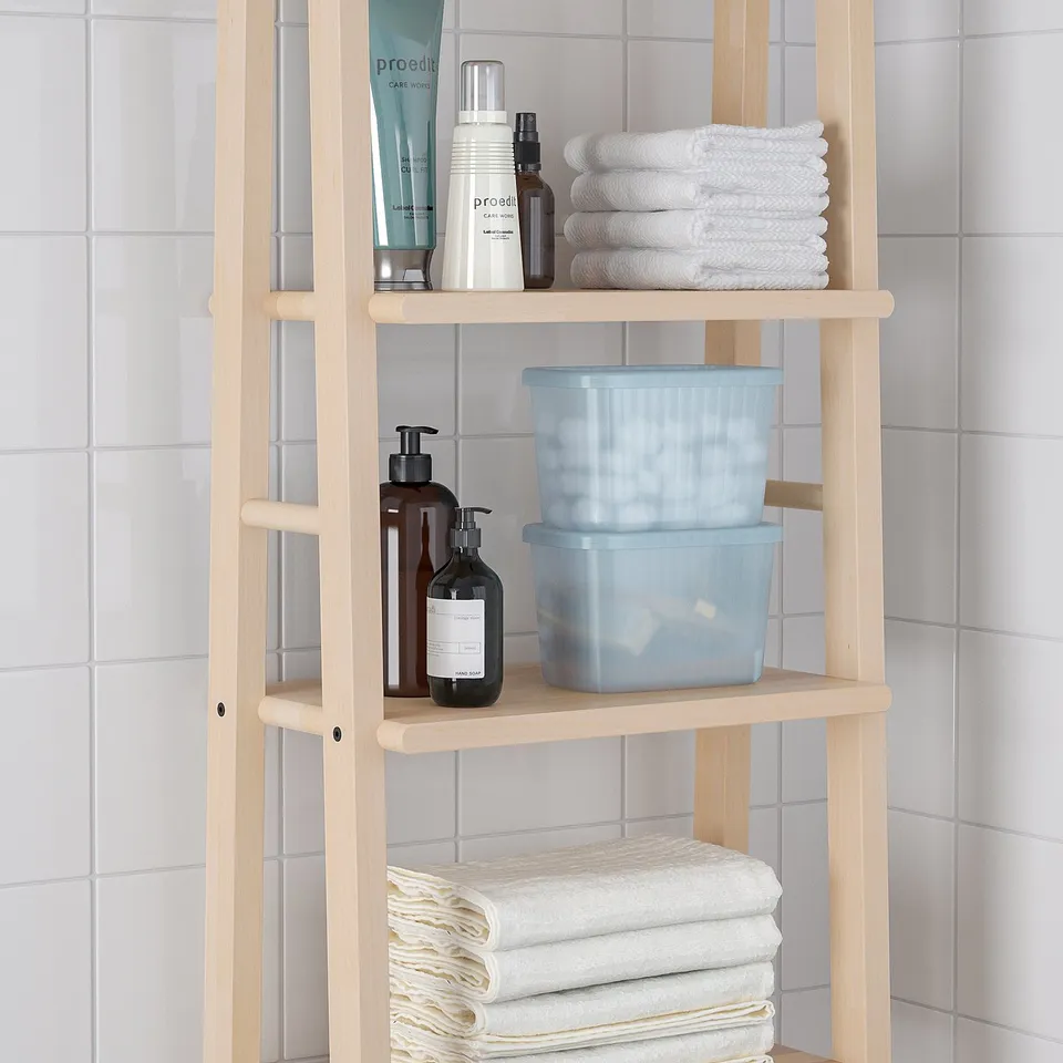 Wooden bathroom shelf with blue boxes and towels. Holds toiletries and organises items.