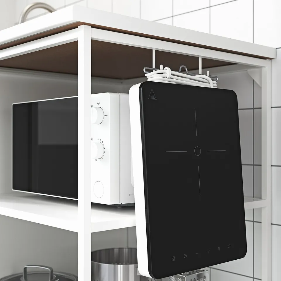 Modern kitchen shelving unit with microwave, tablet holder, and hanging clothes hangers.