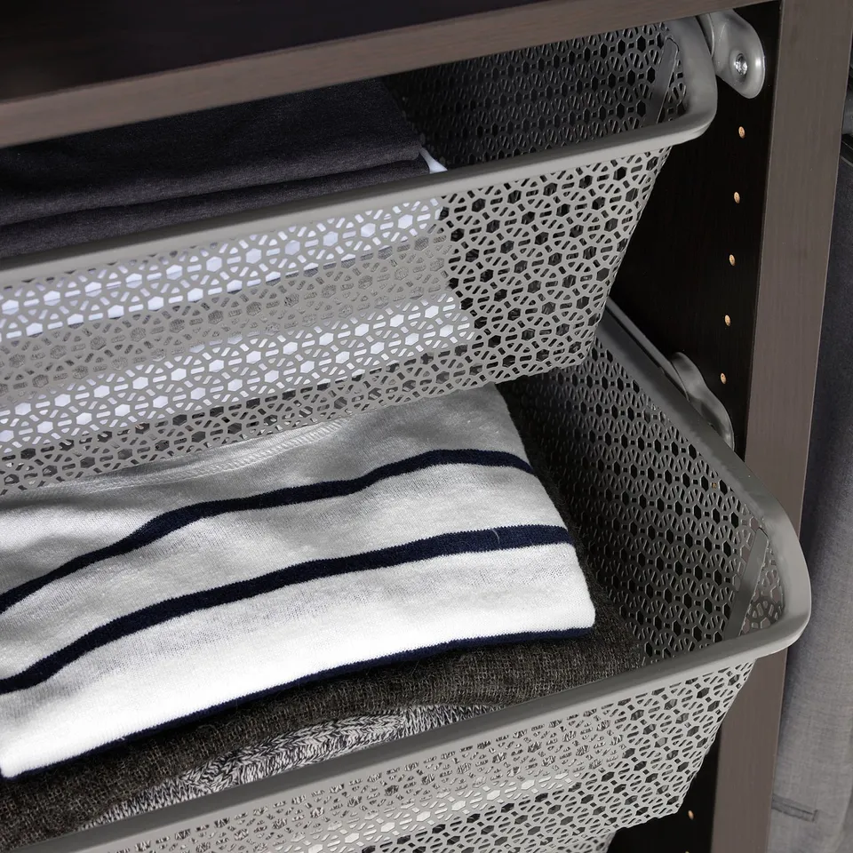 Metal wardrobe basket holding folded clothes, keeping items organised and air-circulating.