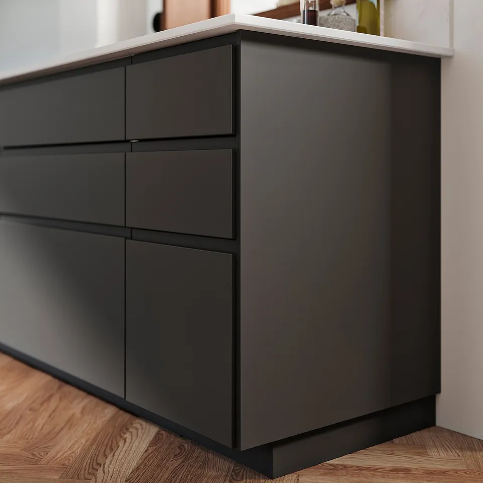 Black FÖRBÄTTRA drawer unit, modern design, four drawers in recycled plastic, sleek handles, wooden floor.