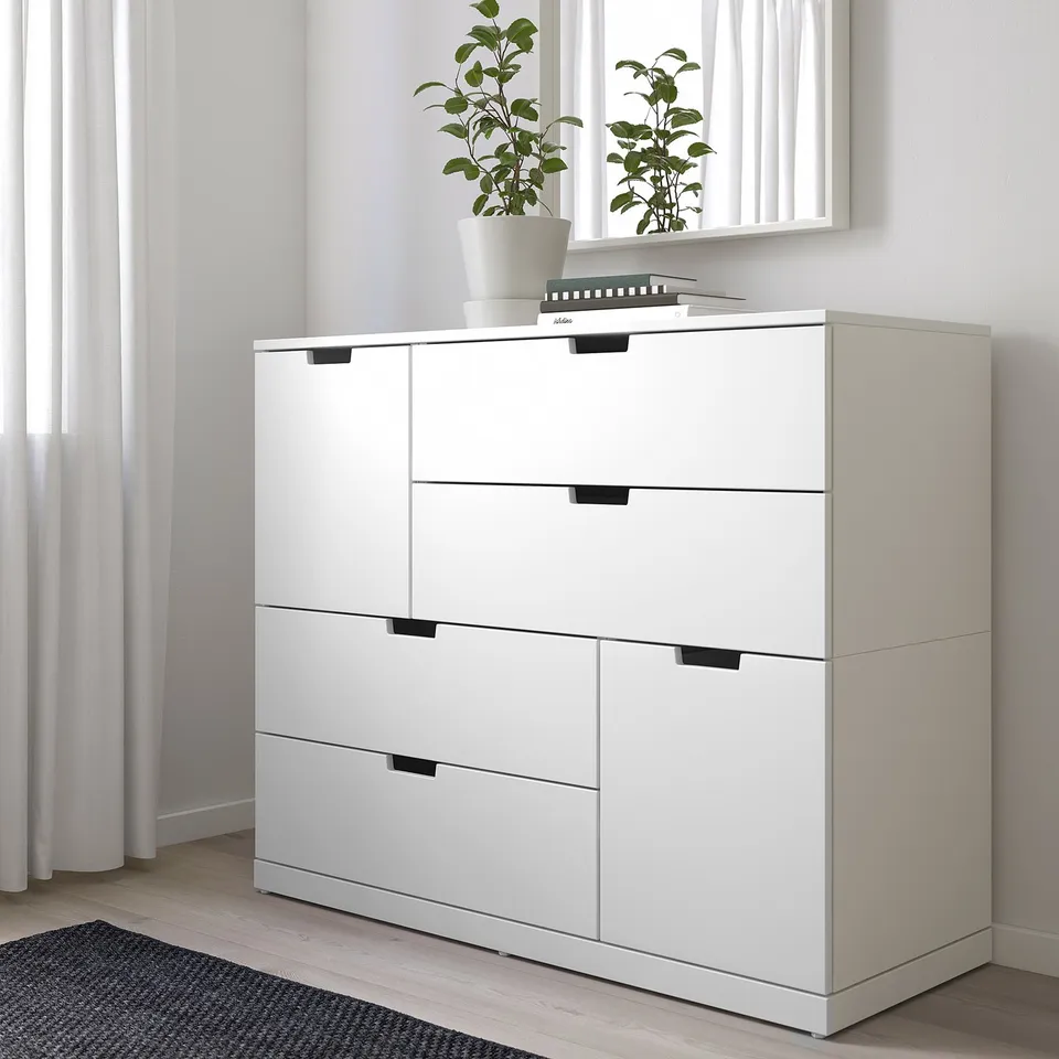 White NORDLI chest of drawers against wall, with houseplant, under window; modern, clean design, size: 4 drawers tall, 2 wide, fits under window.