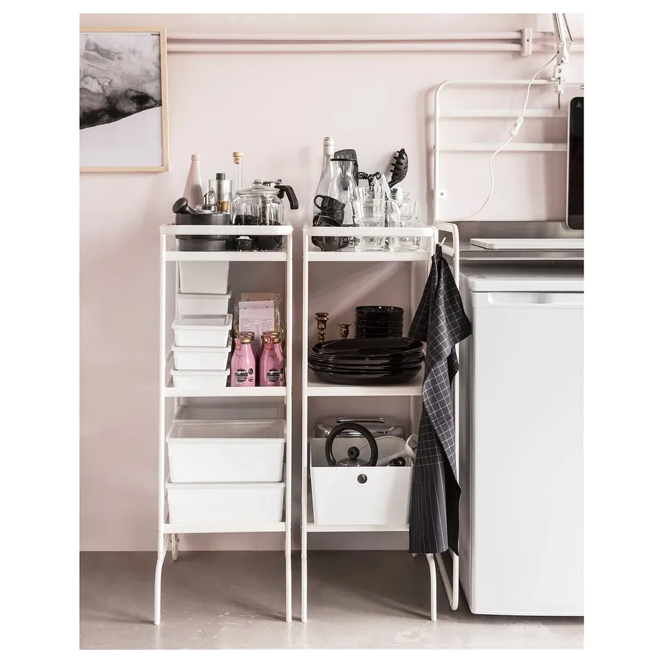 Modern kitchen corner: white shelves with jars, glasses, plates, tools. White fridge, chequered towel.