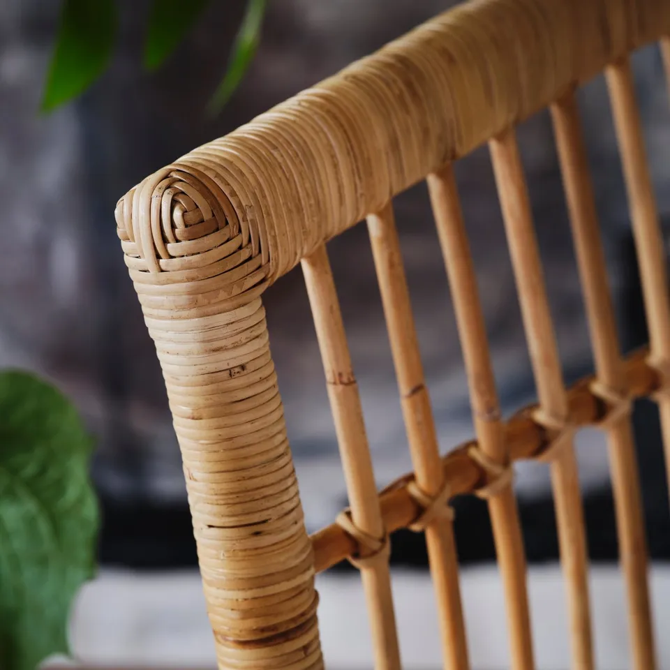 Close-up of woven wicker chair, showcasing intricate craftsmanship and natural texture.