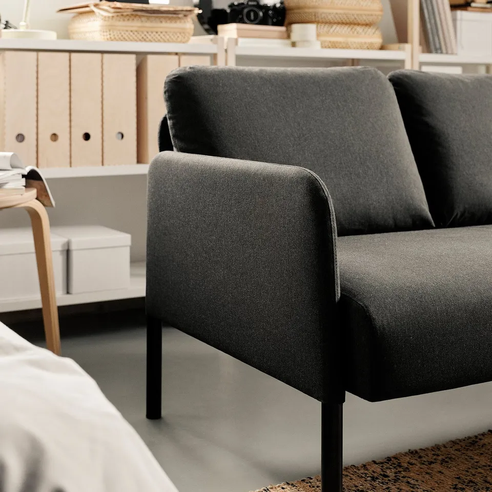 Modern GLOSTAD grey sofa with metal legs in minimalist room.