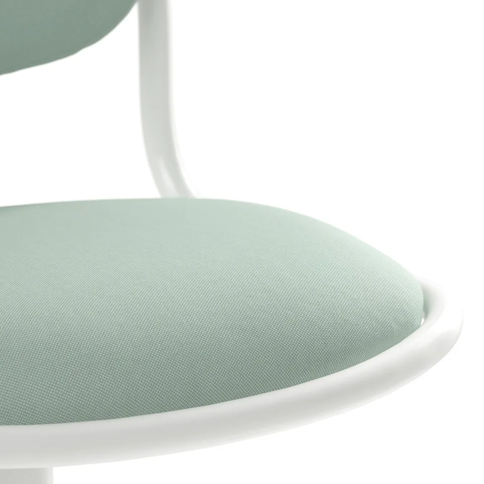Close-up of modern chairs seat, showing soft mint green fabric and white frame edge, offering comfort and style.