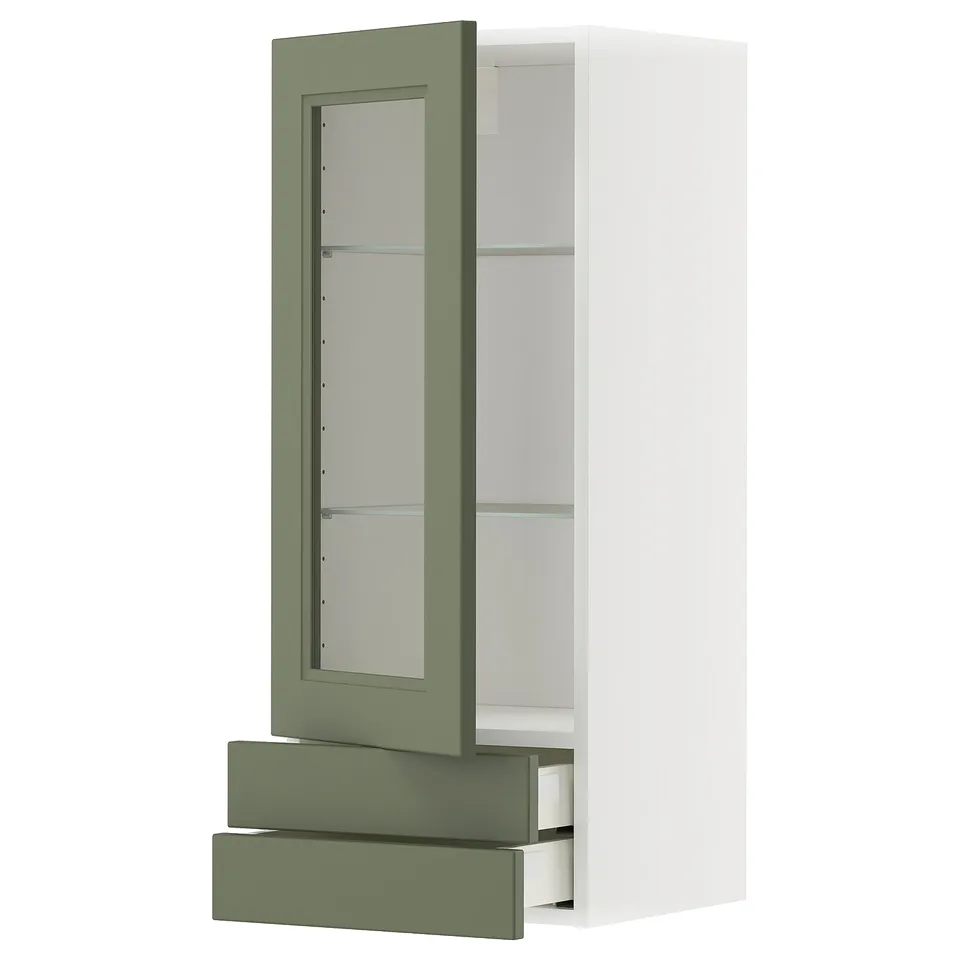 A white ikea METOD kitchen cabinet with grey-green drawers and glass doors.