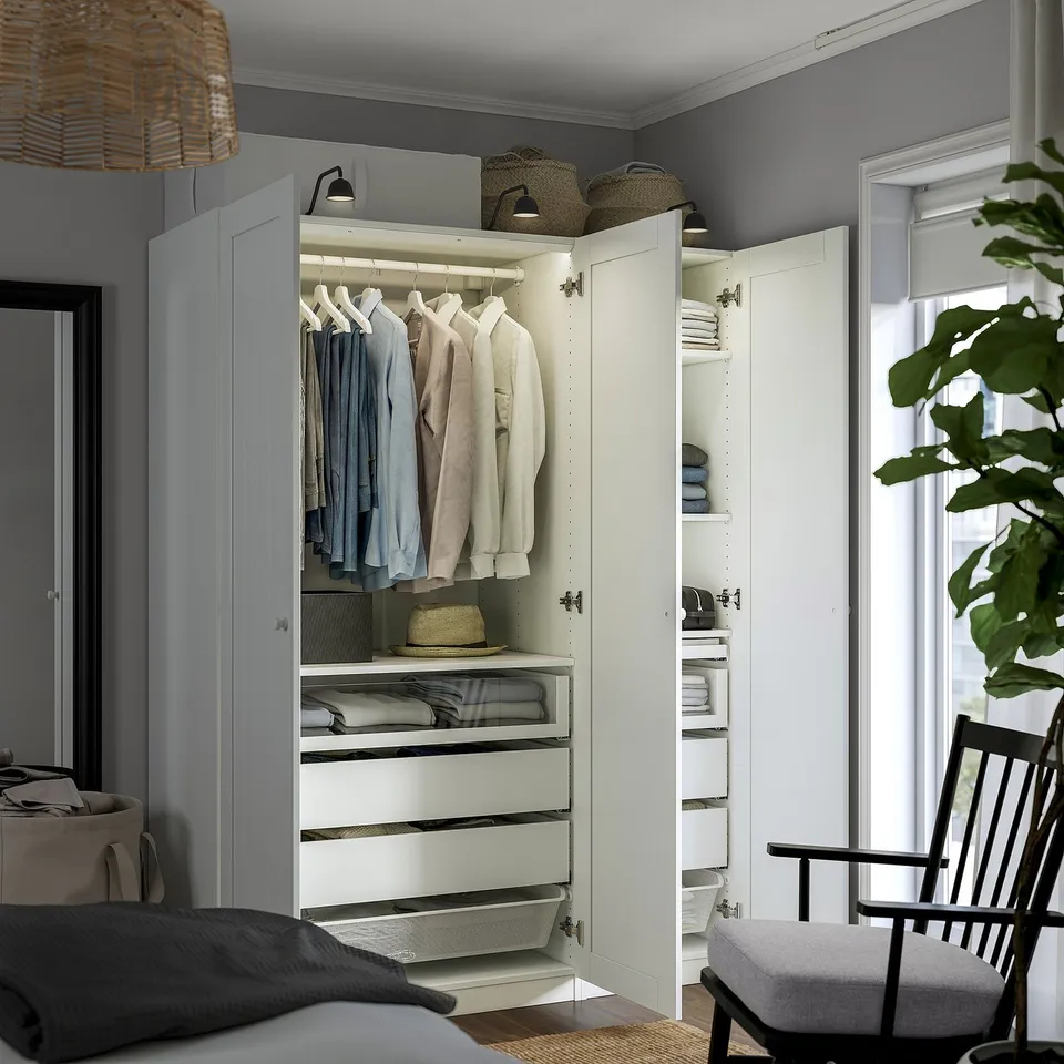 Modern, open wardrobe showcasing organised clothes on hangers, drawers, and shelves. Adjustable feet and integrated lighting.