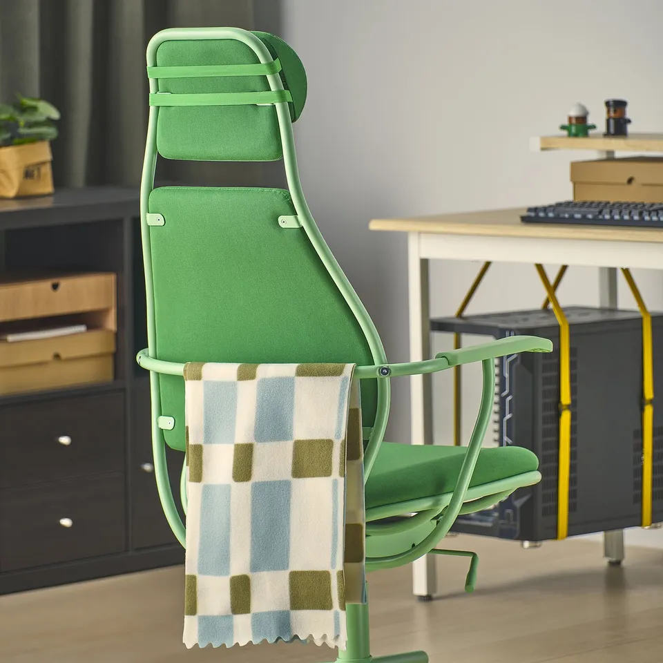 A green gaming chair with adjustable headrest and seat height, designed for comfort and support during long gaming sessions.