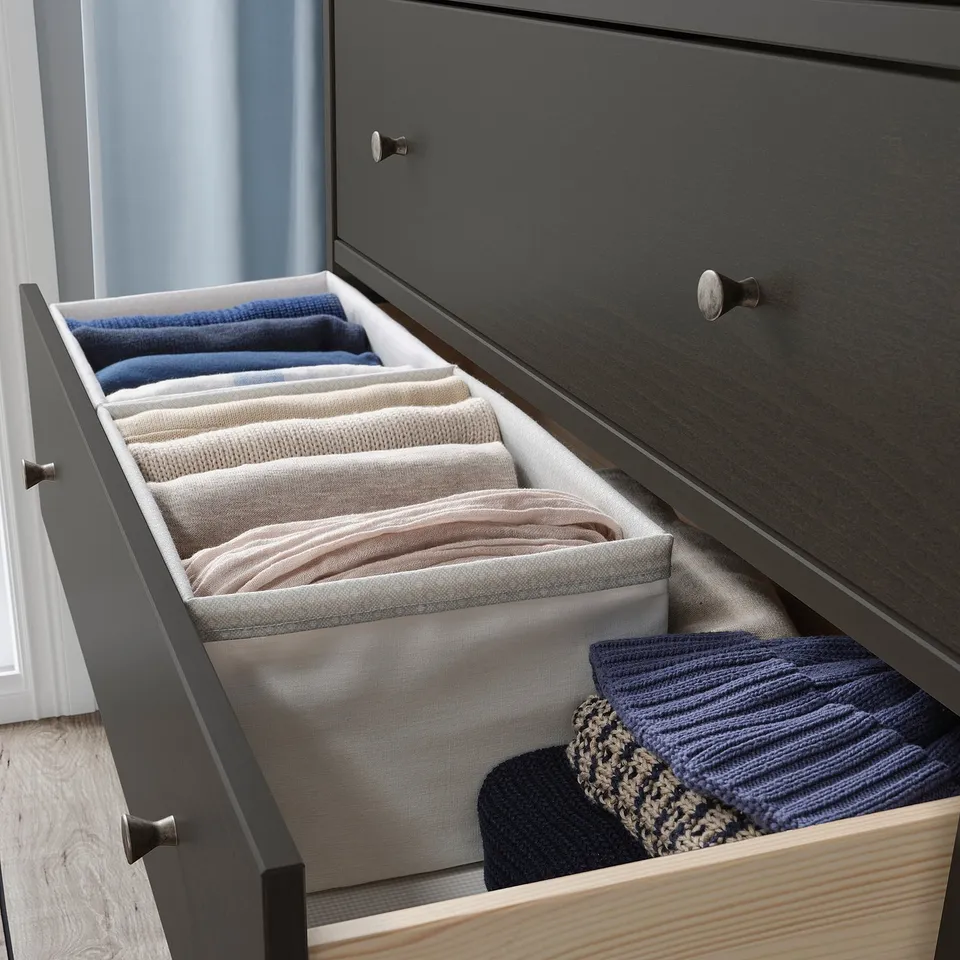 Open drawer organised with BAXNA blue pastel scarves, neatly folded in light grey compartments.