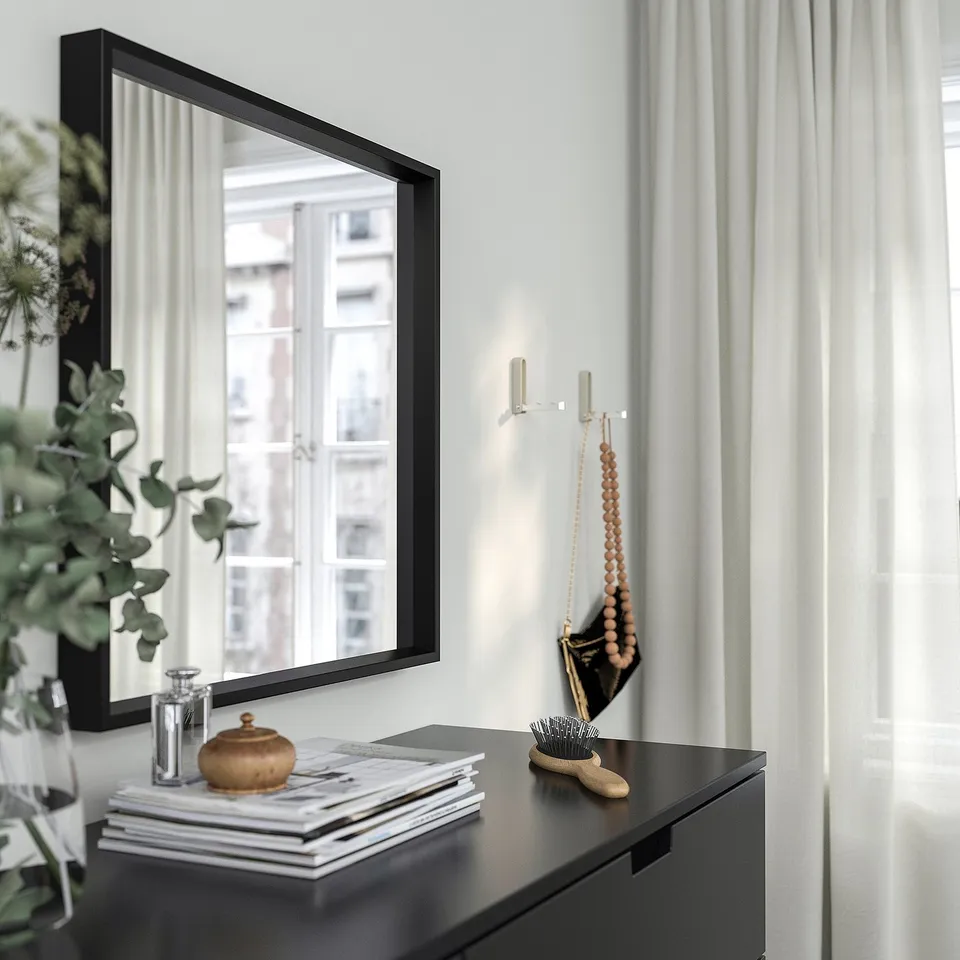 Mirror with city view reflection, books, and decor below
