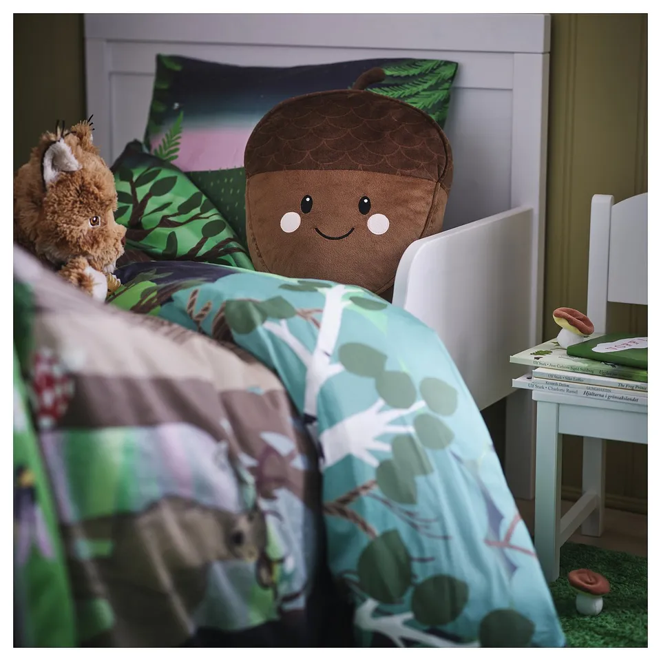 Childs bedroom with acorn pillow, teddy bear, and nature bedding
