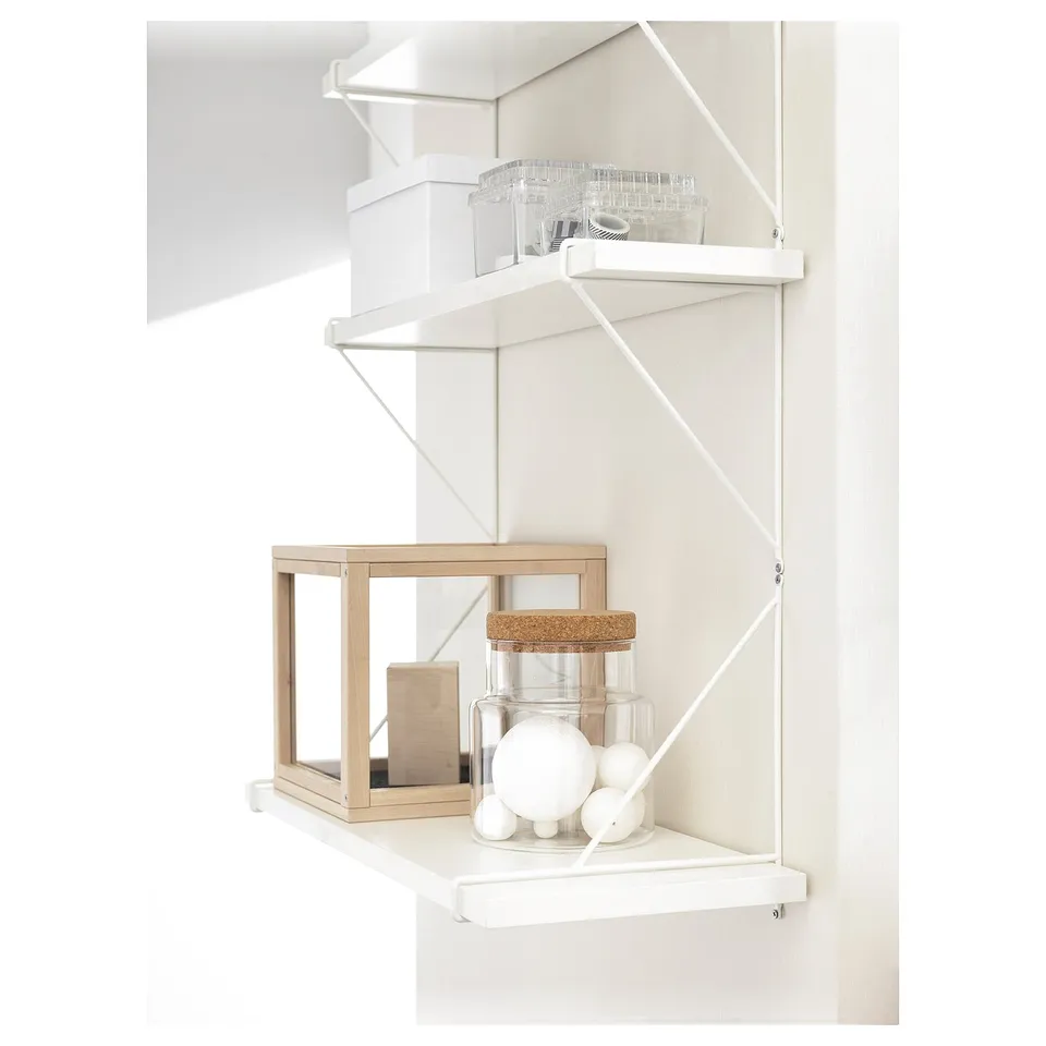 BERGSHULT white wall shelves holding decorative items; the design is minimalist and functional.