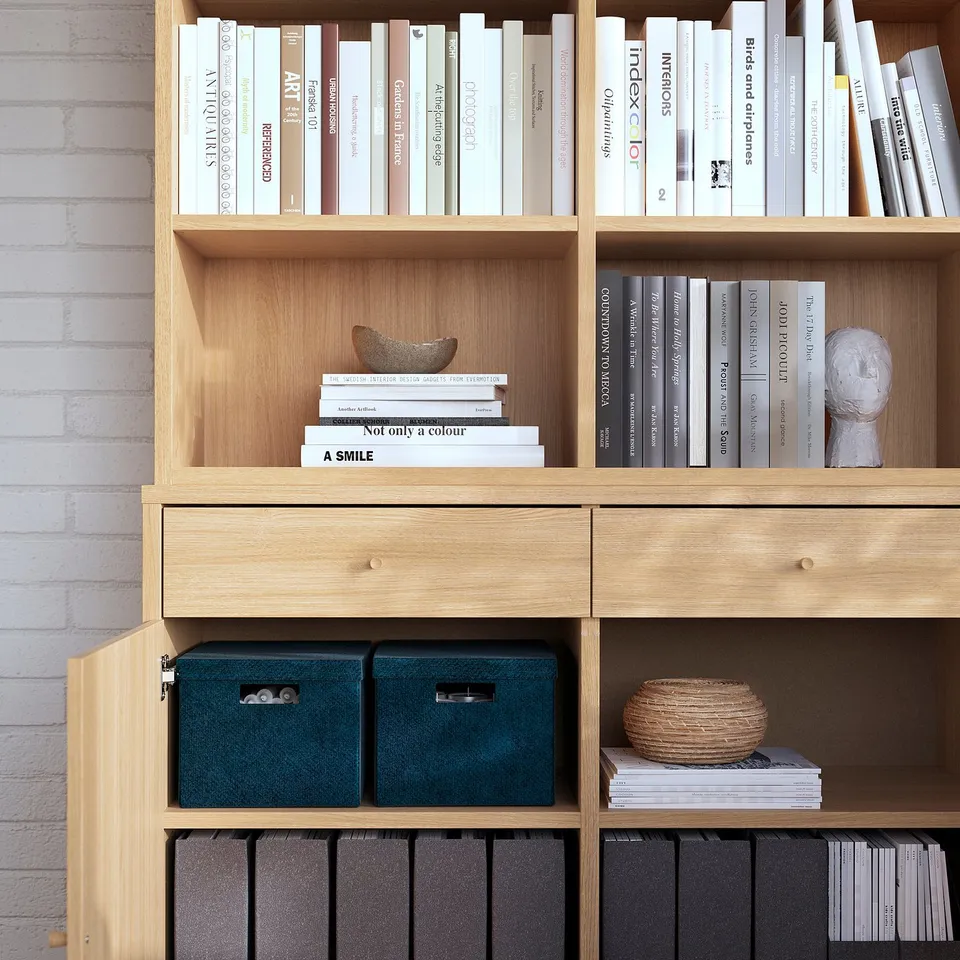 Modern wooden bookshelf with shelves, drawers, and storage boxes showcasing books and decor.