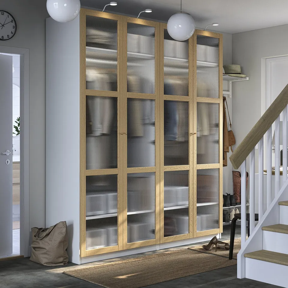 Wooden PAX wardrobe with frosted glass in grey room. Near stairs, with rug and decor.