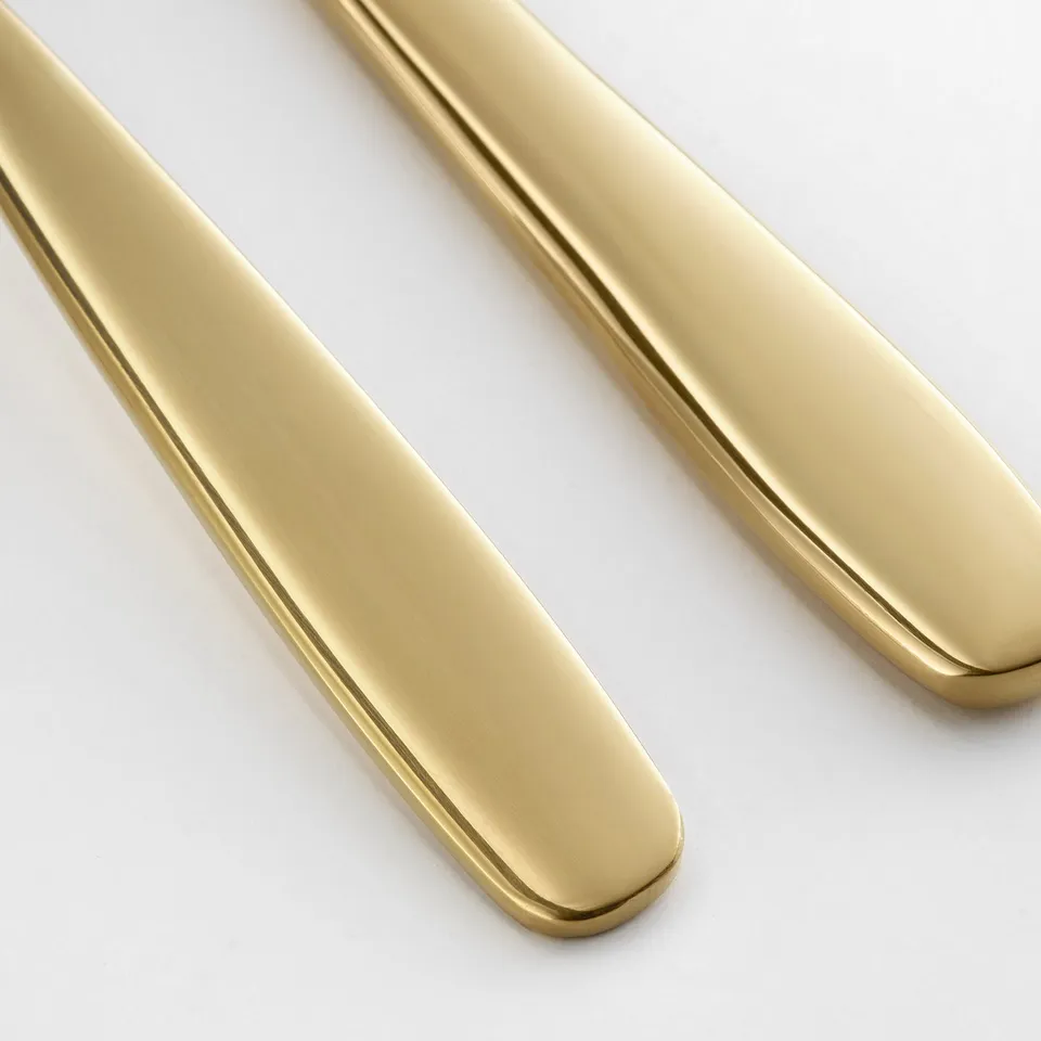 Golden stainless steel cake server and knife, polished smooth and elegantly arranged.