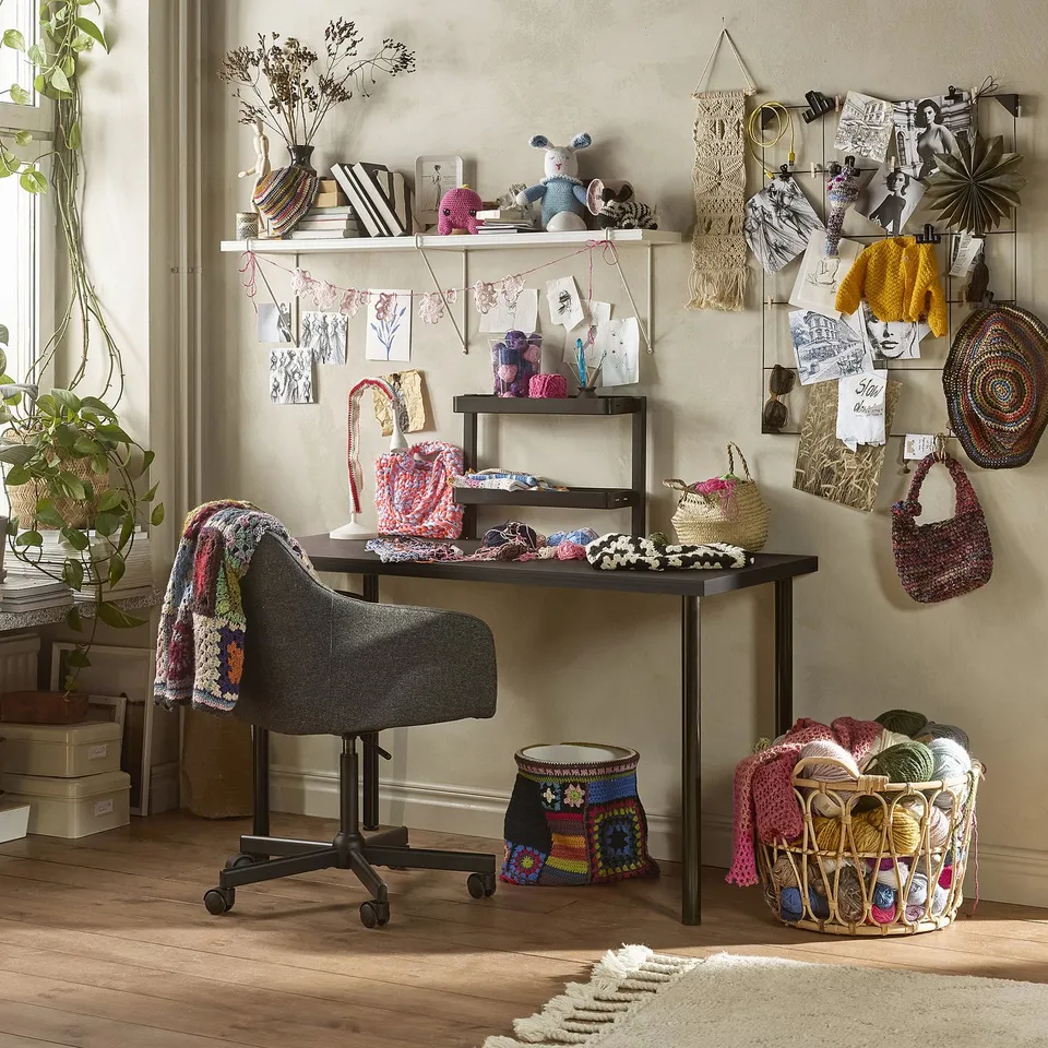 Craft room with LAGKAPTEN desk, black table, yarn, baskets.