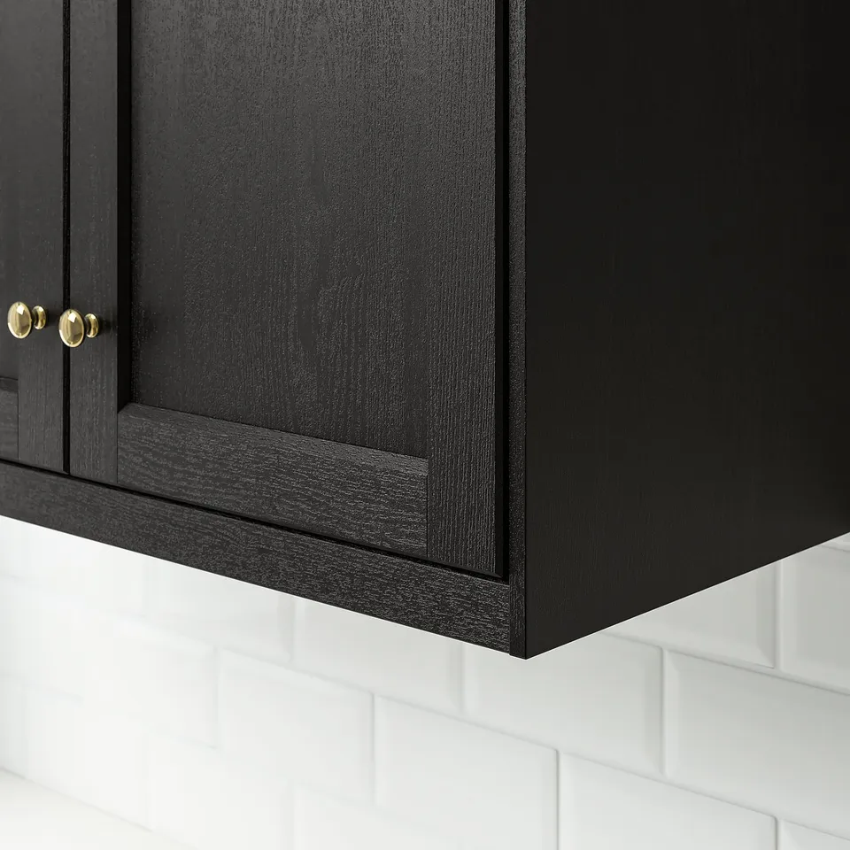 Black wooden cabinet with intricate grain detail and gold knobs.