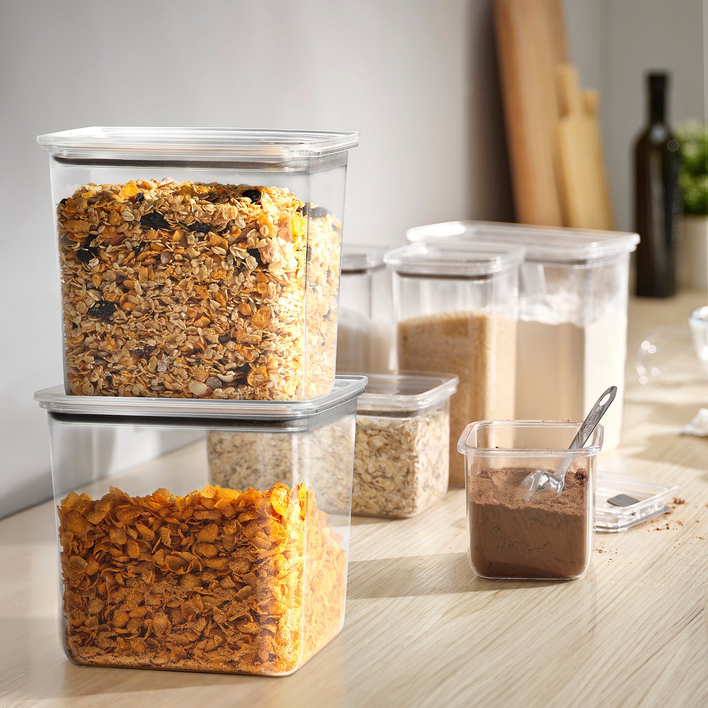 Plastic KORALLVIPPA jars with cereals, stacked on wood, showcase organised kitchen storage.