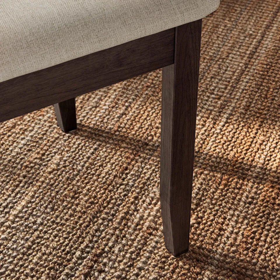 Dark wood-framed cushioned seat on textured floor rug.