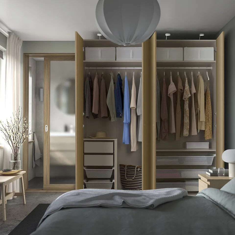 Bedroom with PAX wardrobe, featuring clothes, shelves, and baskets; includes hanging space and drawers.