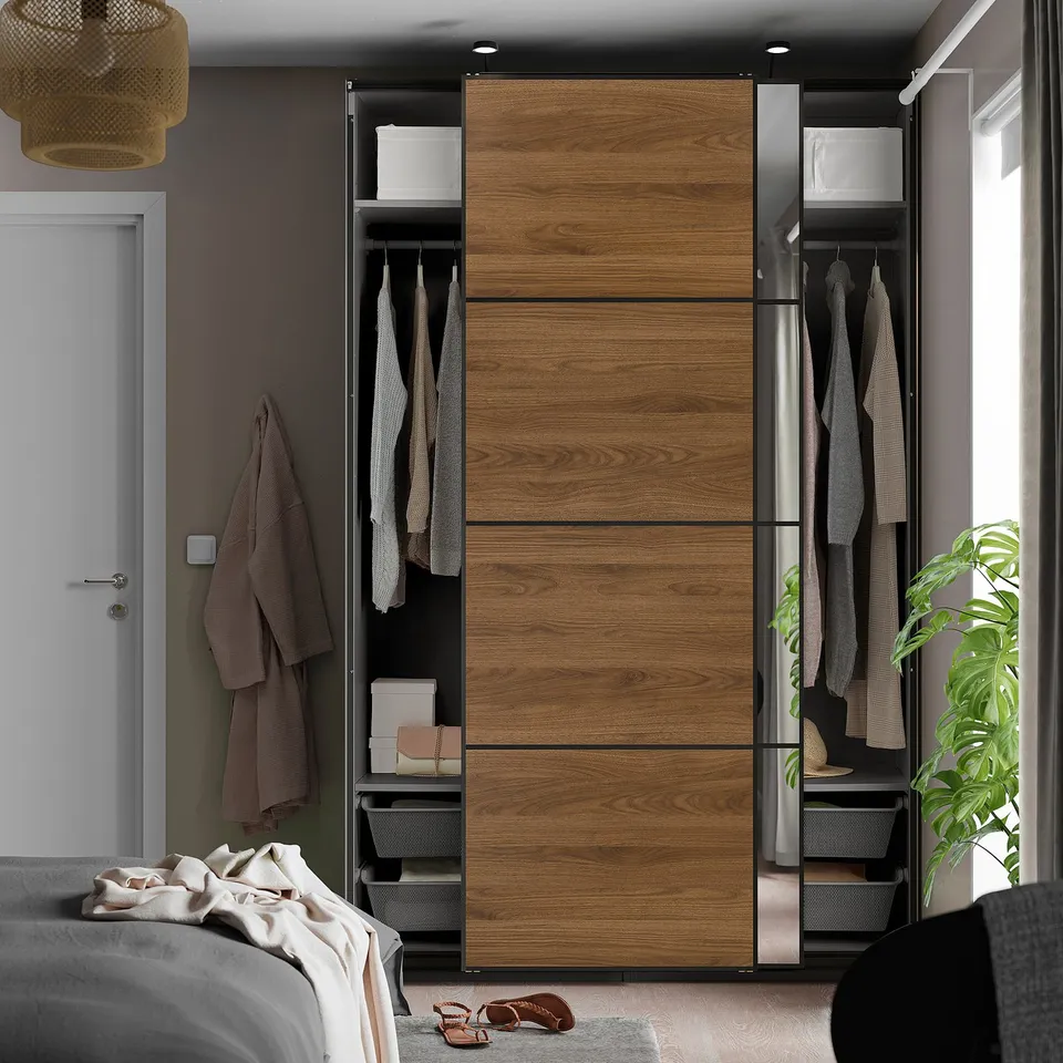 Bedroom with PAX wardrobe featuring sliding doors, hanging clothes, and shelves. Blends functionality and space efficiency.