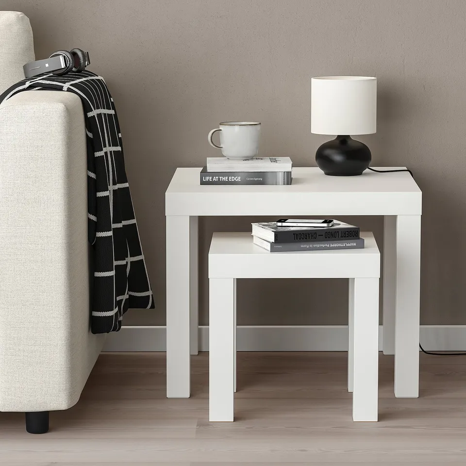 Small white side table, ideal for holding a mug, books, and lamp. Easily slides under larger tables for space-saving.