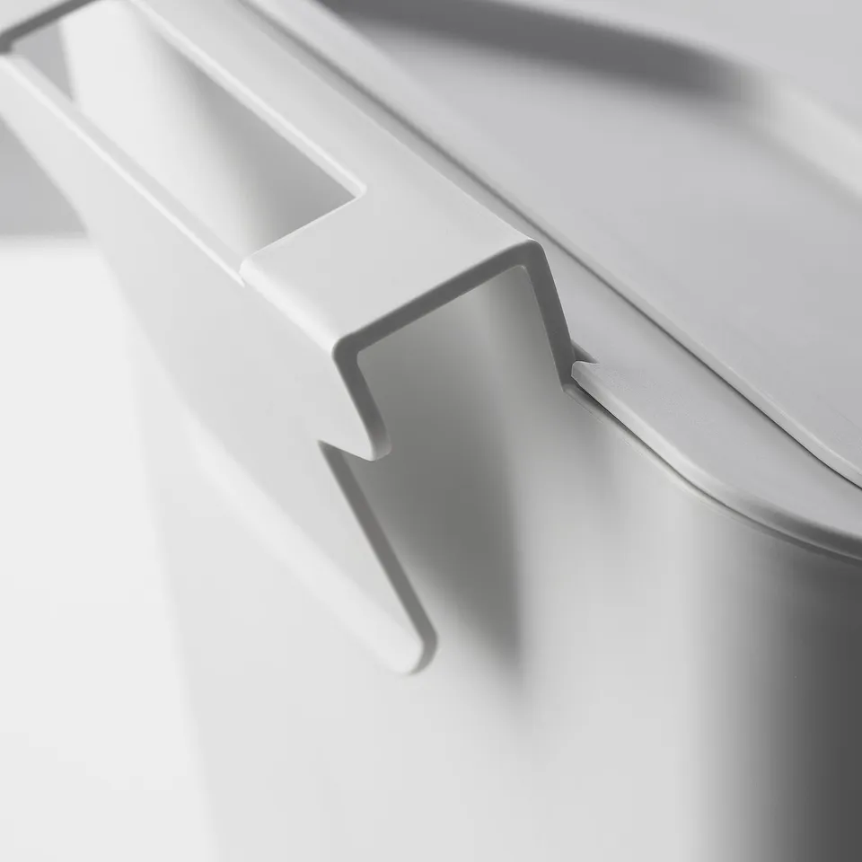 White, durable over-door waste bin with lid for odour control.