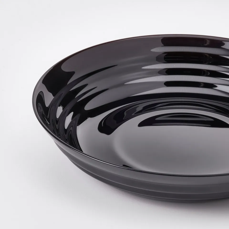Sleek, black, glossy dinner plate with subtle, wavy pattern. High-quality, reflective surface; elegant and rustic design.
