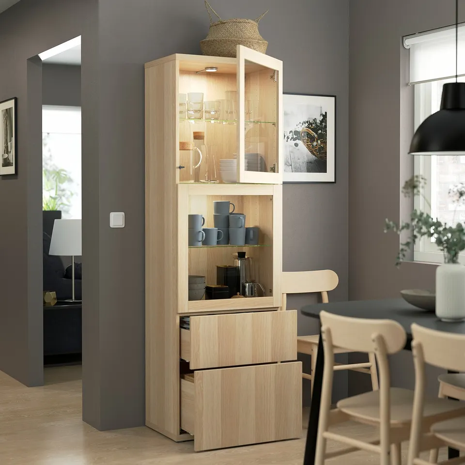 Modern wooden display cabinet with glass doors and drawers in stylish kitchen. Stores and items, with soft-closing drawers.