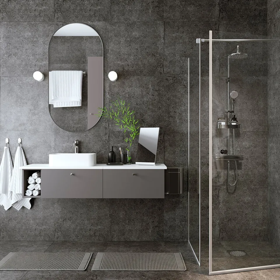 Modern bathroom with grey floating vanity, oval mirror, glass shower screen, chrome fixtures, and wall-mounted tap.