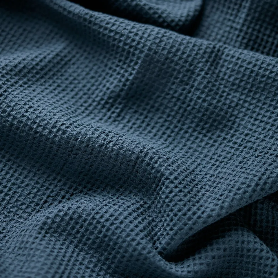 Deep blue, textured towel, detailed weave, folded neatly.