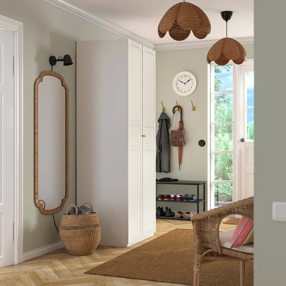 :~ PAX off-white wardrobe, with wicker baskets & mirror, between wall & door, holding coats & bags.