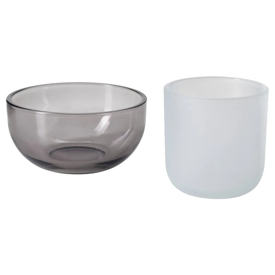 Two glass candle holders, one grey, one white, simple and elegant, for tealights or storage.