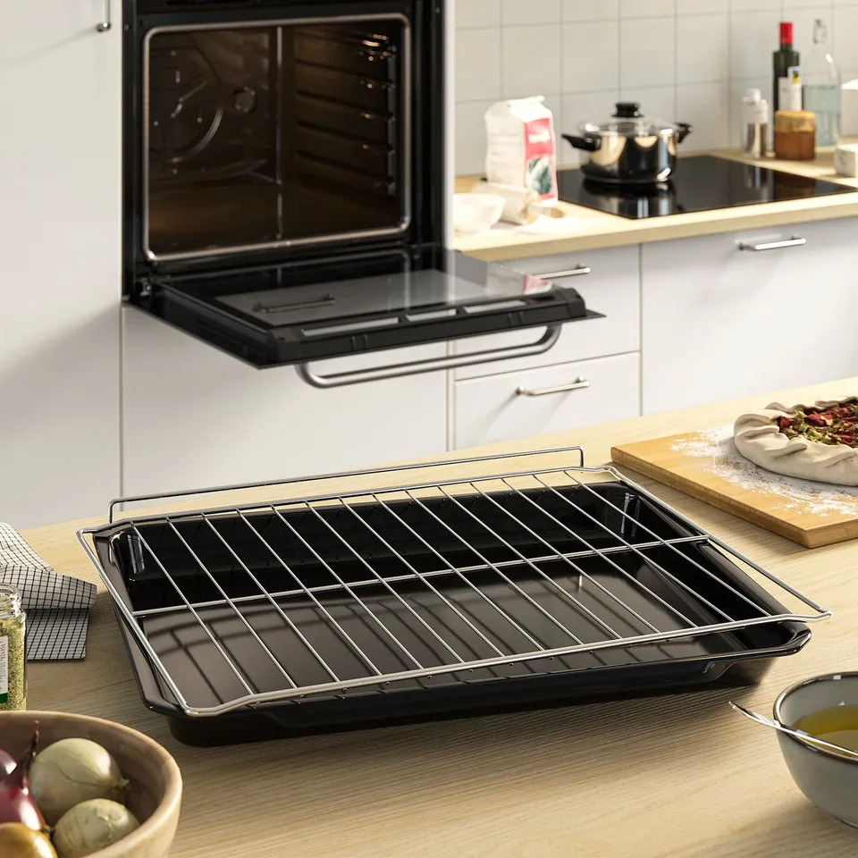 A modern kitchen with an oven, featuring wire racks and baking tray, suitable for cooking and baking.