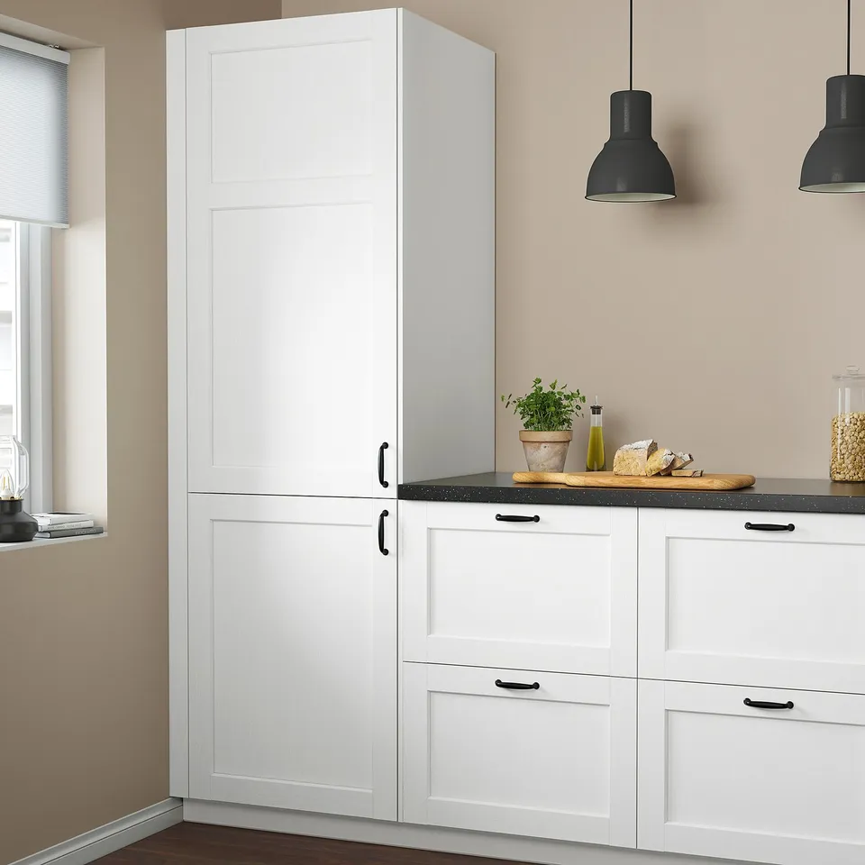 Modern kitchen with tall ENKÖPING cabinet, hanging lights, countertop with plant and food.
