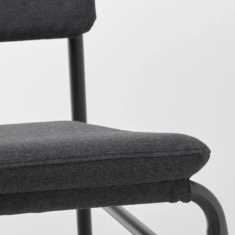 A modern chair in black, featuring a cushioned seat and back. Its sleek design and quality materials offer both comfort and durability.