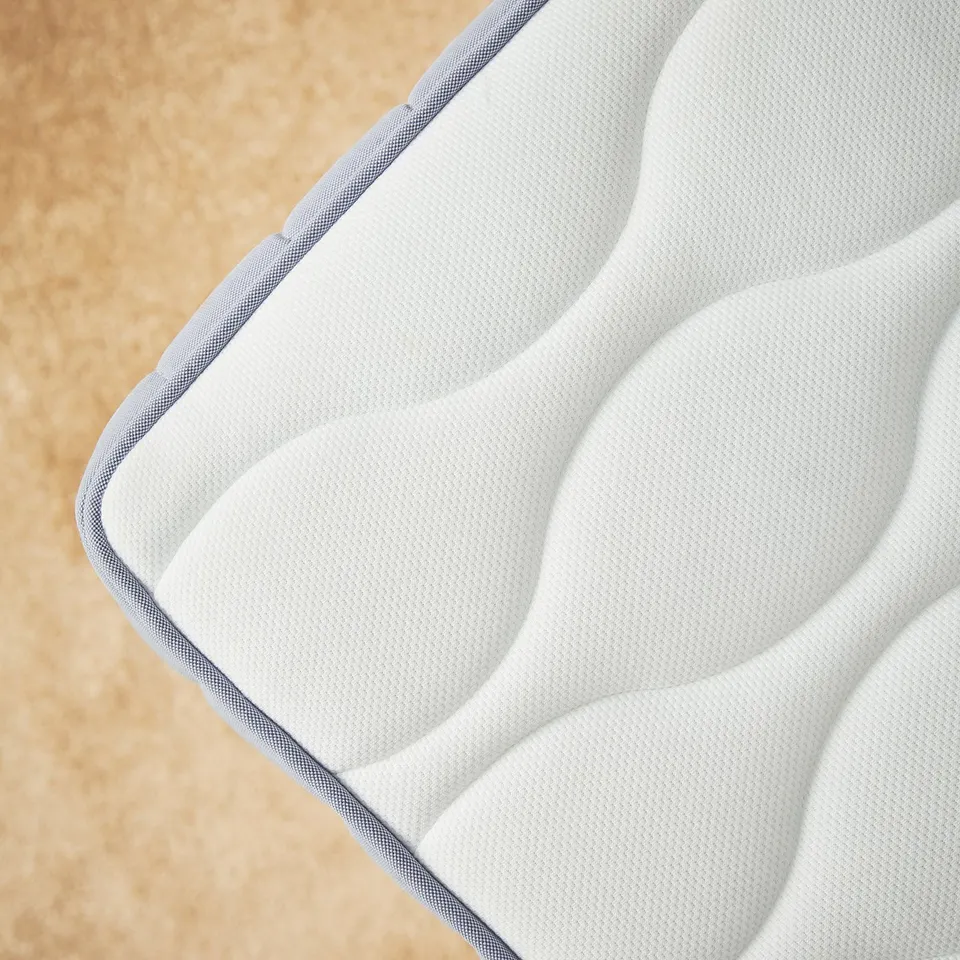 Close-up of VÅGSTRANDA white mattress, textured surface with pocket springs, offering support and comfort.
