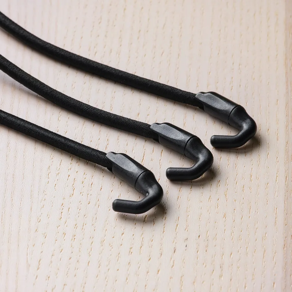 Black elastic cords with sturdy hooks on light-colored wooden surface.