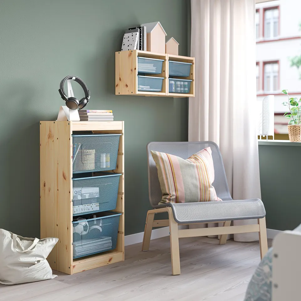 TROFAST storage unit next to chair, mixing rustic wood & modern mesh.