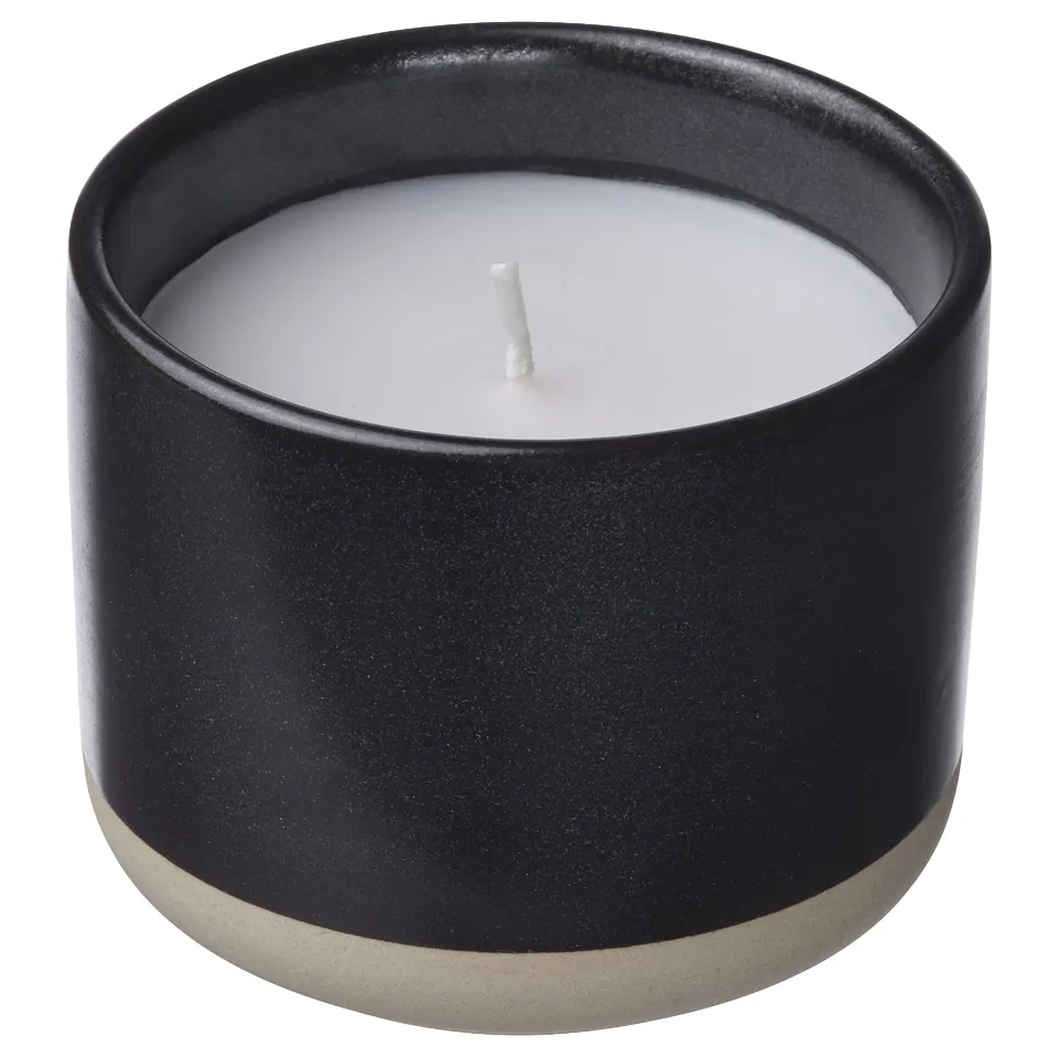 Black ceramic STÖRTSKÖN candle, round shape, white wax, cotton wick.